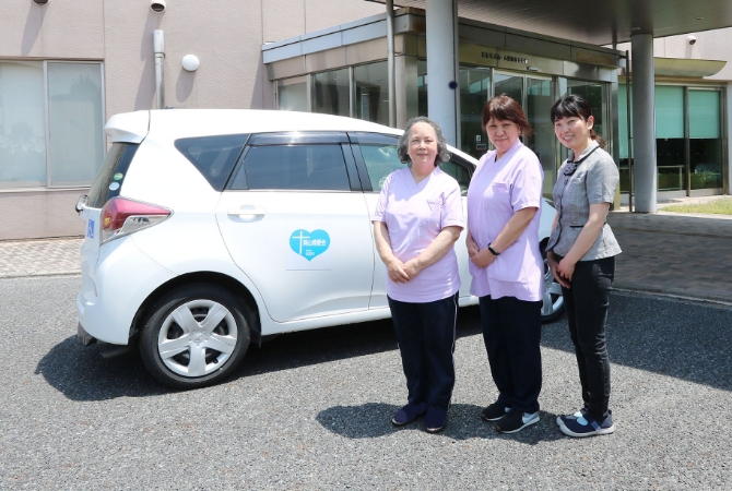 ホサナの正面玄関の前に立つ3人の職員